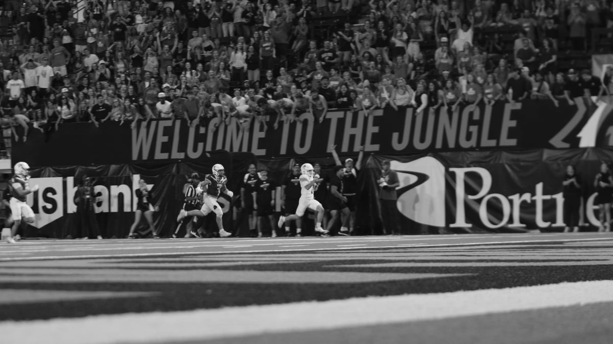 Black and white photo of an ISU football game at Holt Arena with the Welcome to the Jungle banner and packed crowd