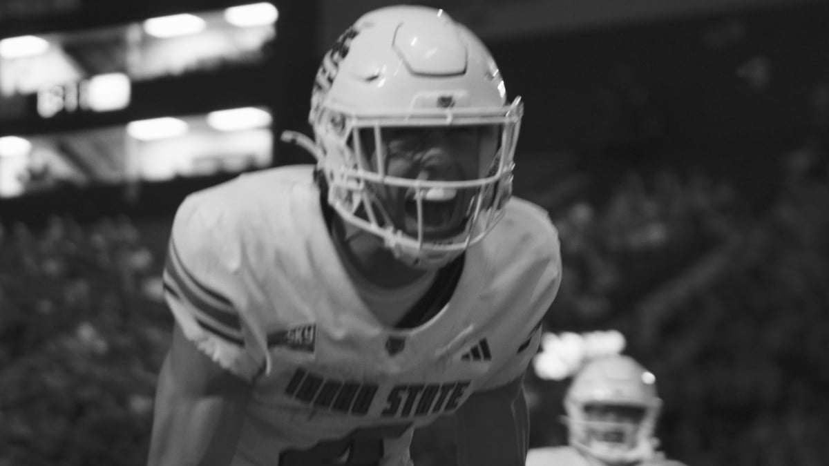 Black and white photo of an Idaho State football player in defensive stance on the field